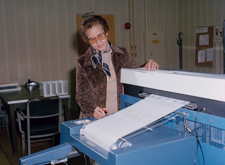Katherine Johnson à côté d'une machine de calculs